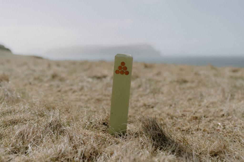 Green poles are marking the hike along Nýpa on Sandoy