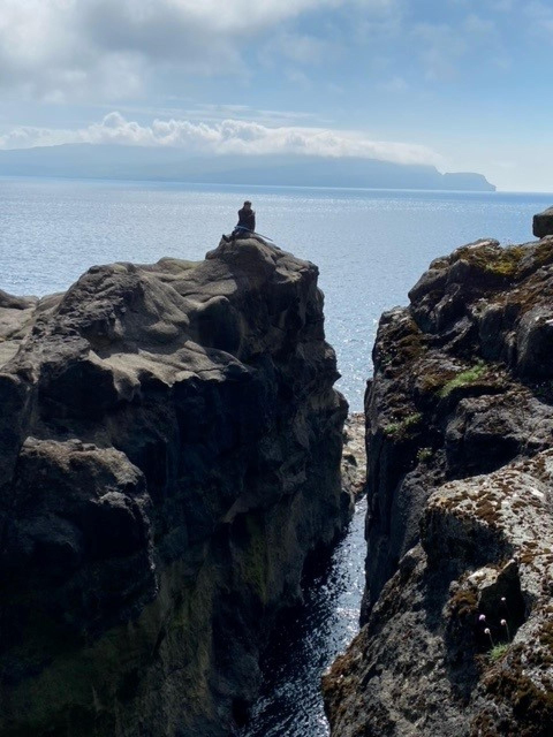 Enjoying the spectacular view of Líðargjógv gorge. Cave hike to Líðargjógv on Sandoy, Faroe Islands